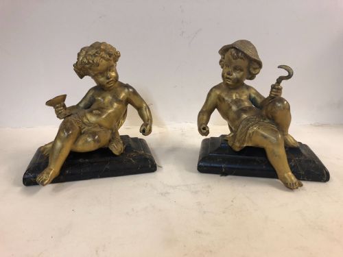 pair of gilt metal cherub ornaments on marble bases