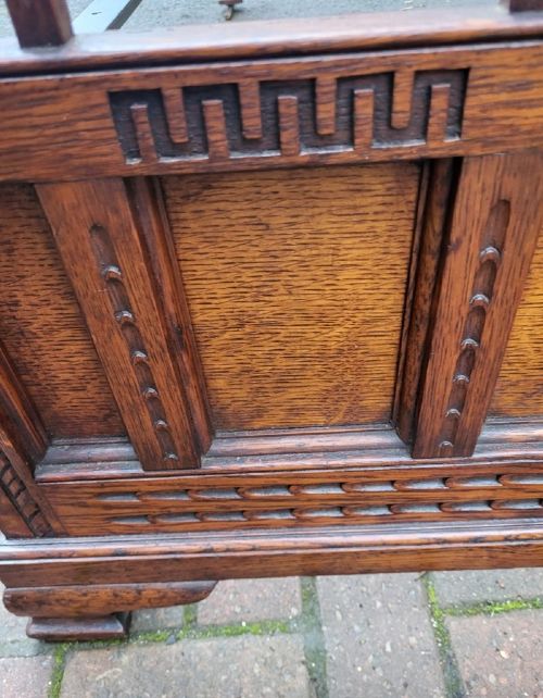 A late Victorian double-sized carved oak bedstead featuring a vertical slatted headboard and footboard with carved geometric friezes. View II