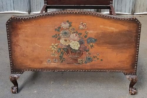 An Edwardian single bedstead with warm brown leather headboard and footboard featuring hand-painted floral urn motifs and brass studding. View IV