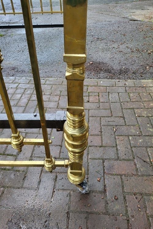 An antique Victorian king-size brass half tester bedstead featuring turned posts, decorative porcelain mounts, and an elevated canopy frame structure. View VI