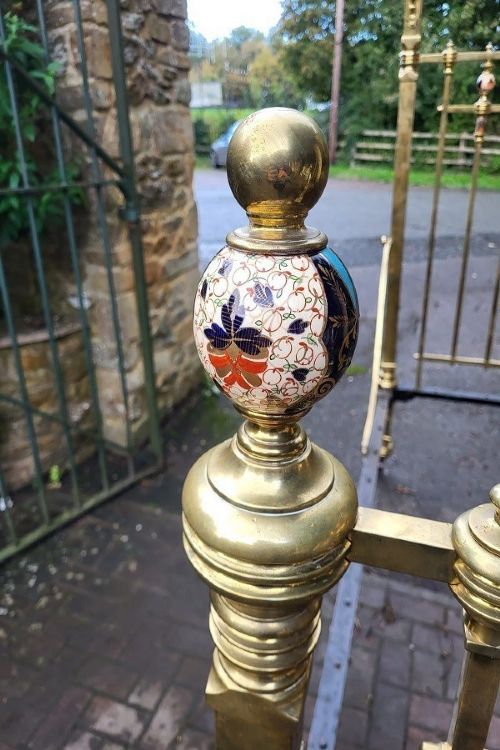 An antique Victorian king-size brass half tester bedstead featuring turned posts, decorative porcelain mounts, and an elevated canopy frame structure. View VII