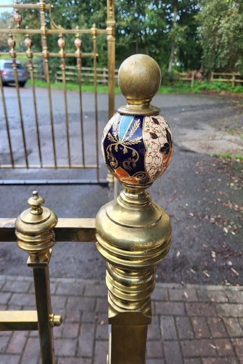 An antique Victorian king-size brass half tester bedstead featuring turned posts, decorative porcelain mounts, and an elevated canopy frame structure. View VIII
