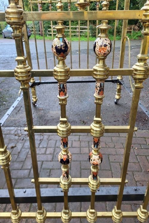 An antique Victorian king-size brass half tester bedstead featuring turned posts, decorative porcelain mounts, and an elevated canopy frame structure. View IX