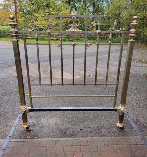fig 1. Victorian double brass bedstead featuring barley twist corner posts, decorative cast scrollwork, and original castors.