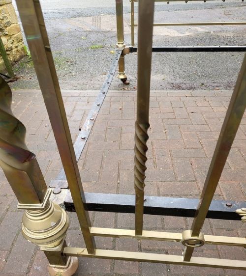 Victorian double brass bedstead featuring barley twist corner posts, decorative cast scrollwork, and original castors. View V
