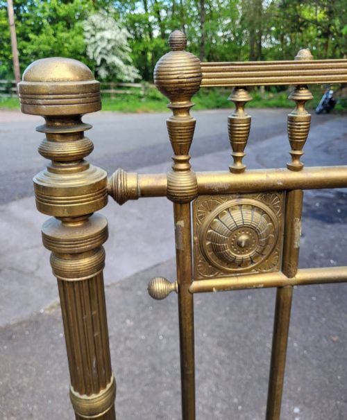fig 1. A Victorian Aesthetic Movement king size brass bedstead featuring vertical spindles, geometric corner panels with roundels, and turned posts.