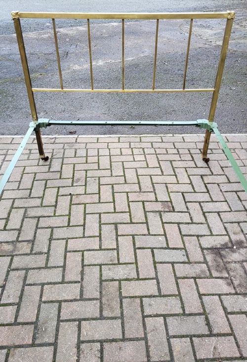 A late Victorian double-sized brass bedstead featuring vertical spindled headboard and footboard panels supported by a green-painted cast iron frame. View II