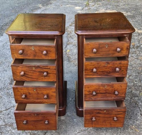 A matching pair of narrow Victorian mahogany bedside chests featuring four drawers each with turned wooden knobs and brass escutcheons on a solid plinth base. View II