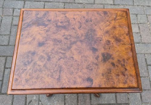A Victorian burr walnut sewing table featuring a rectangular hinged top, a tapering fretwork work well, and a carved pedestal base resting on four cabriole legs. View II