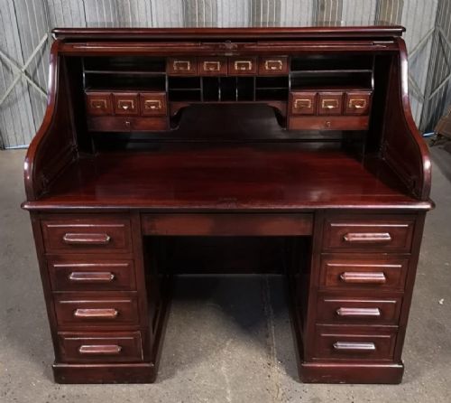 A Victorian mahogany roll top desk featuring twin pedestals, multiple drawers, and a closed slatted tambour cover. View II