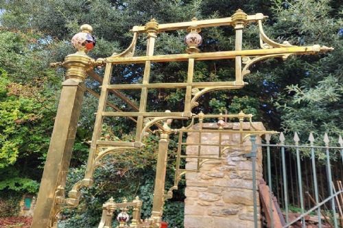A Victorian king-size half tester bedstead made of brass, featuring ceramic mounts, turned posts, castors, and an overhead canopy frame. View IV
