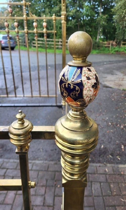 A Victorian king-size half tester bedstead made of brass, featuring ceramic mounts, turned posts, castors, and an overhead canopy frame. View VI