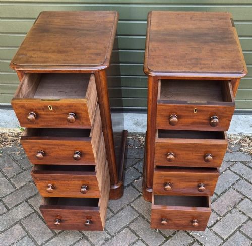 A matching pair of tall Victorian mahogany bedside chests with four drawers each, round wooden knobs, and solid plinth bases. View II