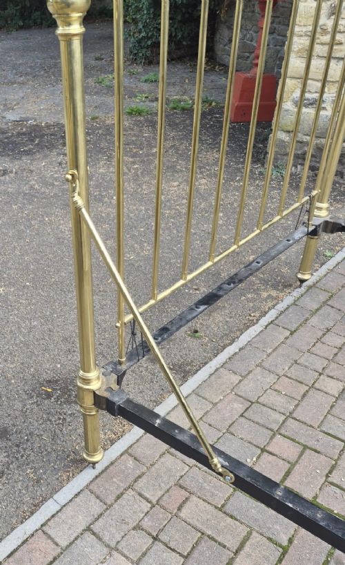 A Victorian brass half tester bedstead featuring an intricate scrolled headboard, turned corner posts, decorative finials, and an upper canopy frame. View III