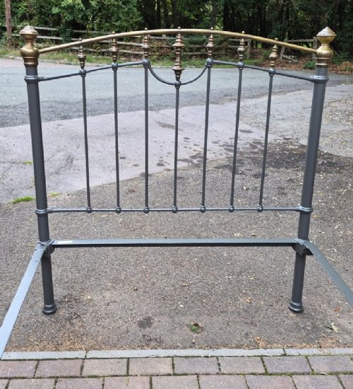 A Victorian double bedstead featuring a dark grey painted iron frame with vertical spindles and a top rail adorned with brass finials. View II