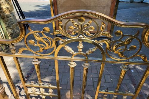 An antique Victorian double-size brass half tester bedstead featuring urn finials, turned corner posts, and intricate cast brass scrollwork on the footboard. View IV