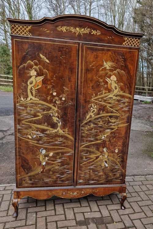 A four-piece Edwardian walnut bedroom suite featuring hand-painted Chinoiserie motifs, comprising a bedstead, wardrobe, dressing table, and chest of drawers with cabriole legs. View X