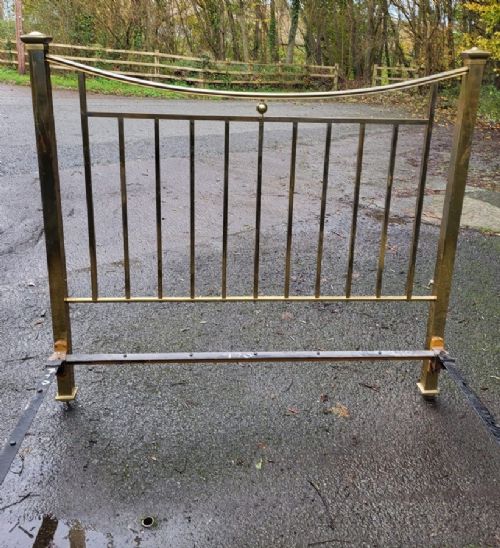A Victorian brass single bedstead featuring a curved top rail, vertical spindles, square corner posts, and finials. View II