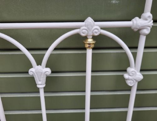 A Victorian king-size metal headboard painted white with a decorative brass top rail, corner finials, and vertical spindles. View II