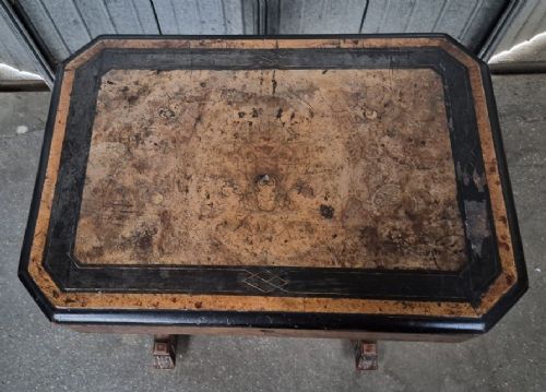 An antique Victorian burr walnut sewing table featuring ebonised banded inlay, a drop-down work basket, turned column legs, and a stretcher base with carved feet. View II
