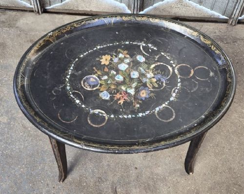 An oval black lacquered Victorian papier-mache tray table featuring mother-of-pearl floral inlay and gilt detailing on curved legs. View II