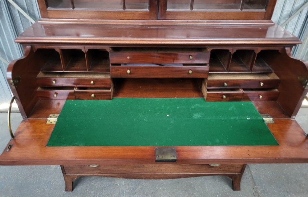 A Georgian mahogany secretaire bookcase featuring an upper cabinet with gothic astragal glazed doors above a lower chest of four drawers with brass handles. View IV