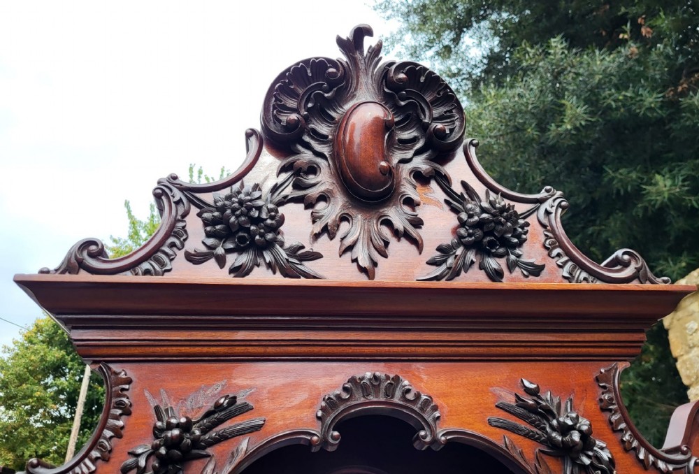 An ornate Victorian carved mahogany mirror-back cabinet featuring a central carved panel door, curved glazed side displays, top mirrors, and cabriole legs. View IV