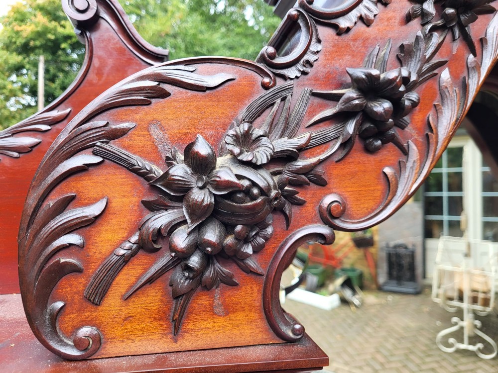 An ornate Victorian carved mahogany mirror-back cabinet featuring a central carved panel door, curved glazed side displays, top mirrors, and cabriole legs. View V