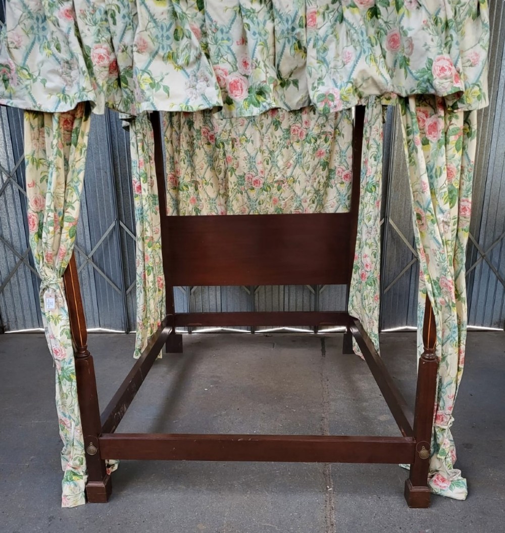 An Edwardian king size mahogany four poster bedstead featuring turned finials, a plain headboard panel, and floral textile curtains. View III