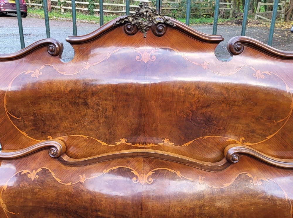 An Italian Rococo king-size walnut bedstead with serpentine contours and marquetry inlay, flanked by two matching marble-topped bombe bedside cabinets. View III