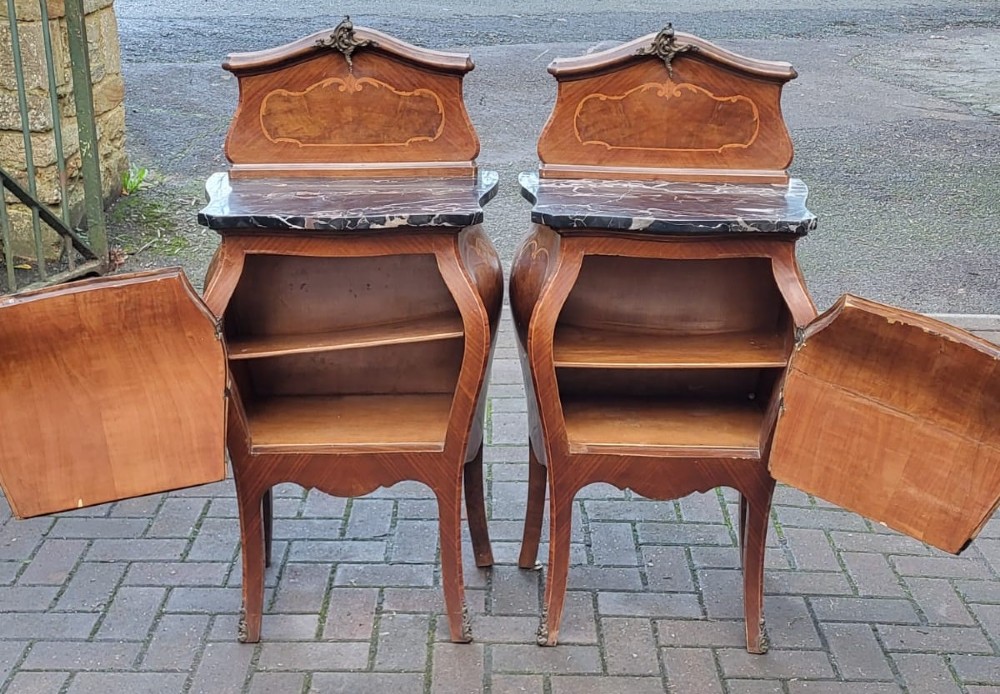 An Italian Rococo king-size walnut bedstead with serpentine contours and marquetry inlay, flanked by two matching marble-topped bombe bedside cabinets. View V