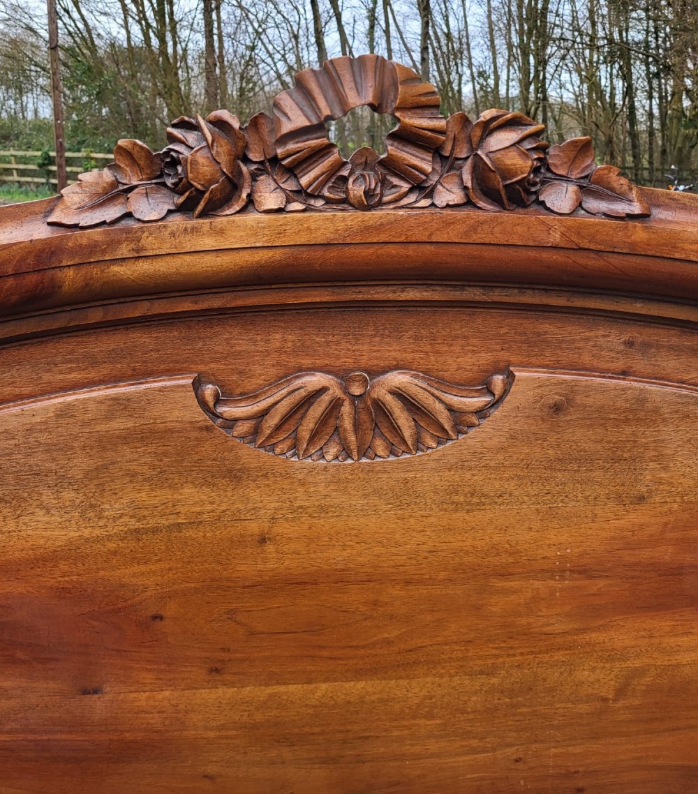A late 19th-century French carved walnut bedstead featuring an arched cresting headboard and a decorative carved oval footboard panel. View III
