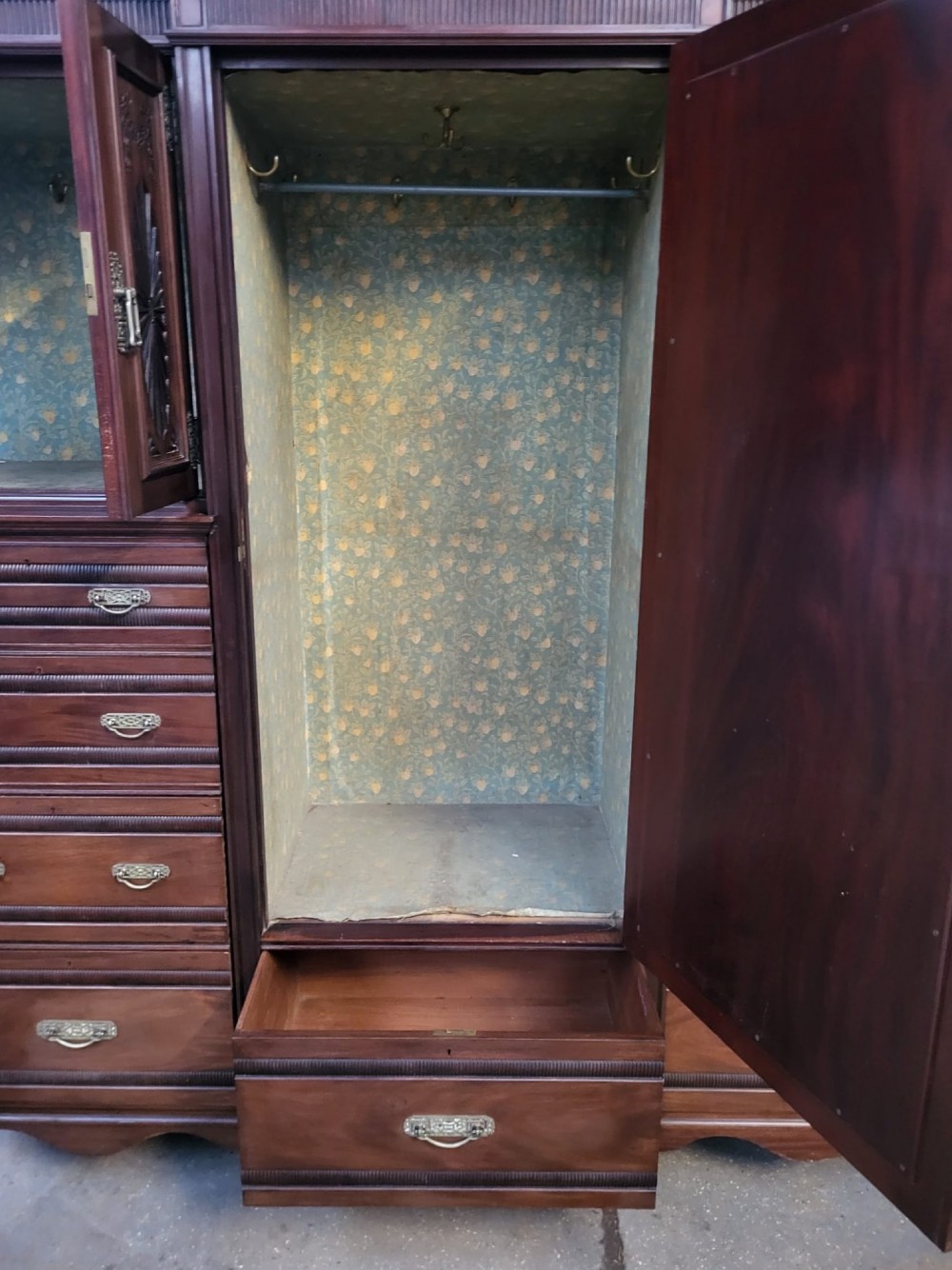 An Edwardian walnut bedroom suite comprising a breakfront compactum wardrobe with a central mirrored door alongside a matching dressing table with drawers and a swivel mirror. View V