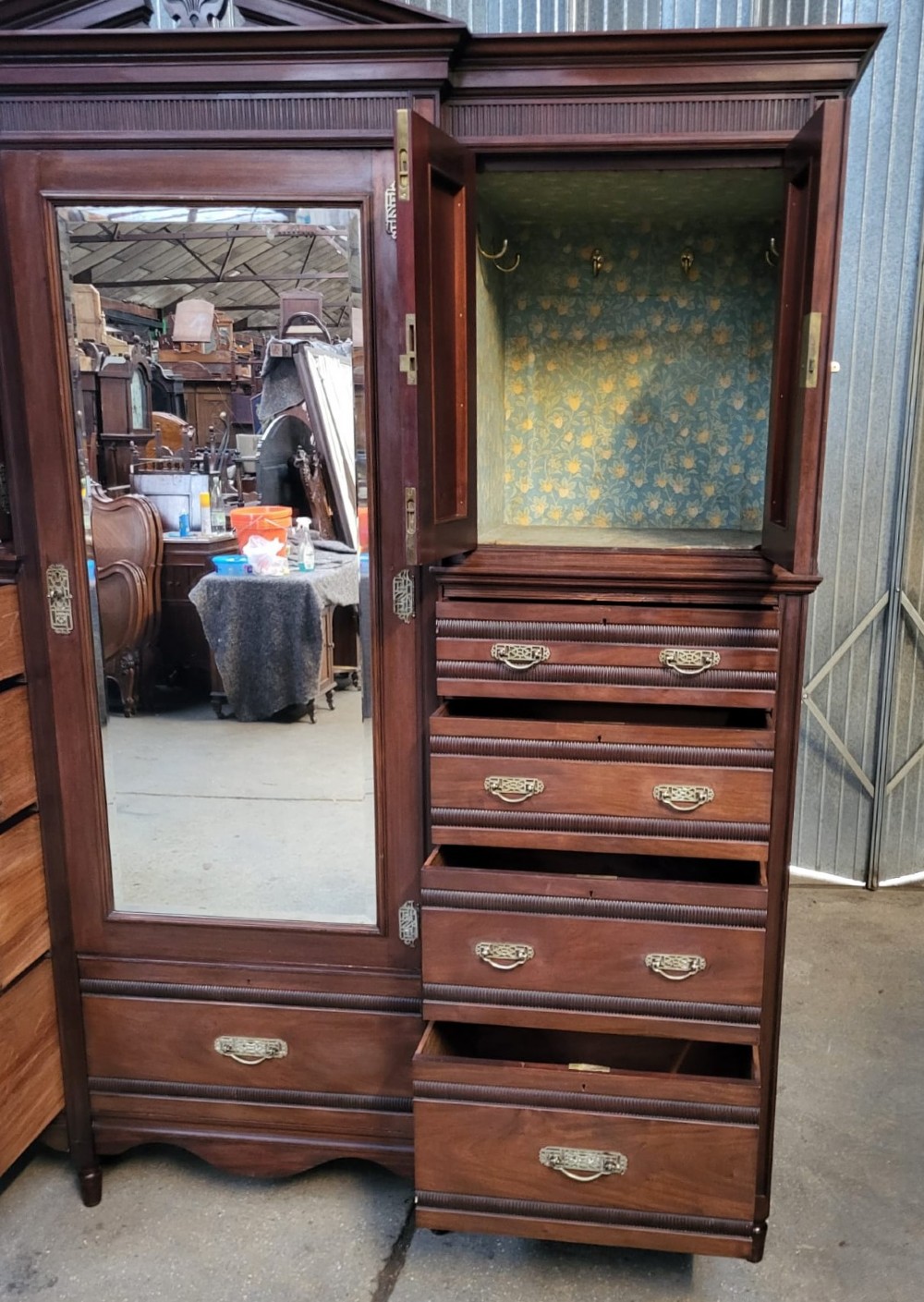 An Edwardian walnut bedroom suite comprising a breakfront compactum wardrobe with a central mirrored door alongside a matching dressing table with drawers and a swivel mirror. View VI