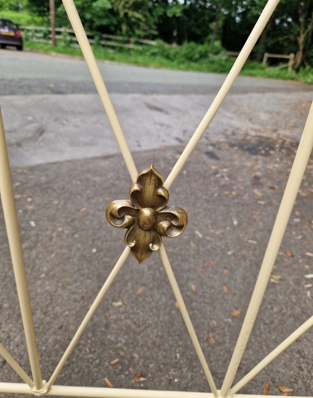A Victorian brass and iron single bedstead featuring twisted brass corner posts with urn finials, cream-painted arched metal framework with brass rosettes, and a green base. View III