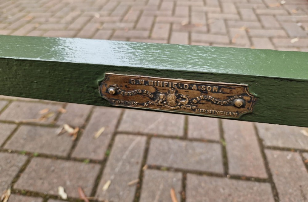 A Victorian brass and iron single bedstead featuring twisted brass corner posts with urn finials, cream-painted arched metal framework with brass rosettes, and a green base. View IV