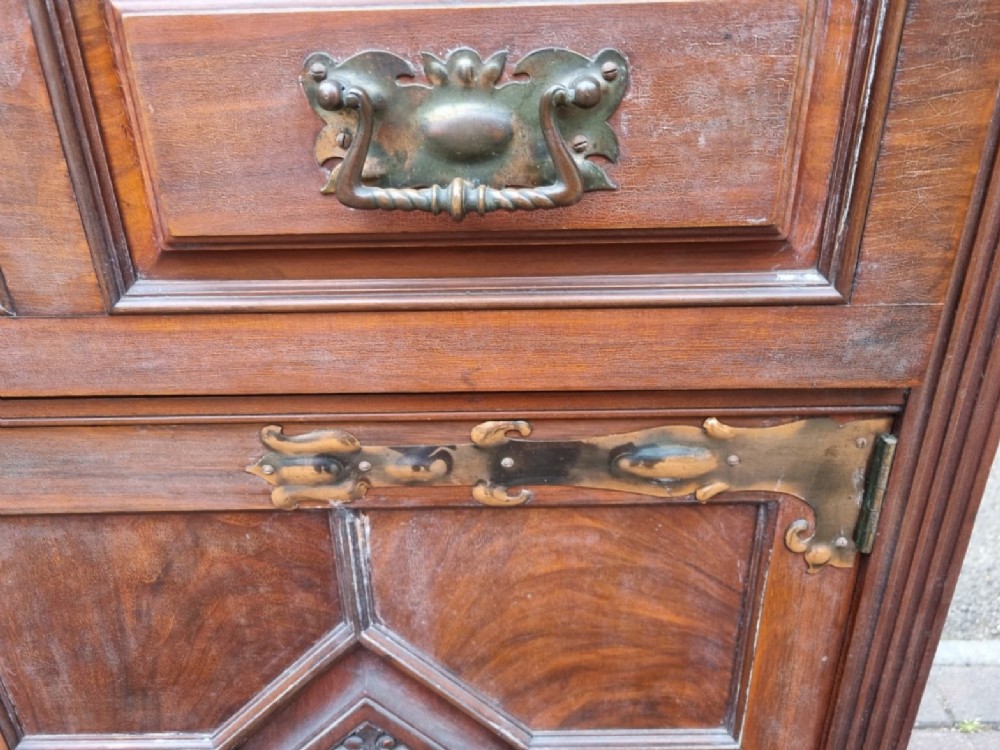 An Edwardian mahogany secretaire bookcase featuring geometric leaded glazed upper doors, metal corner brackets, and carved diamond-panelled lower cupboard doors. View IV