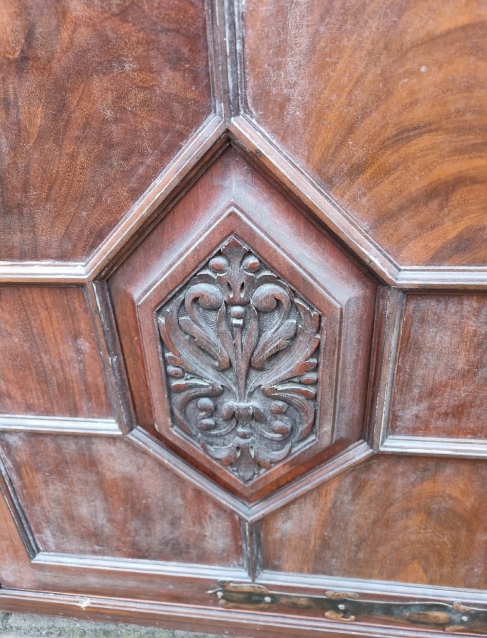 An Edwardian mahogany secretaire bookcase featuring geometric leaded glazed upper doors, metal corner brackets, and carved diamond-panelled lower cupboard doors. View V