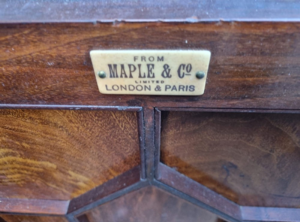 An Edwardian mahogany secretaire bookcase featuring geometric leaded glazed upper doors, metal corner brackets, and carved diamond-panelled lower cupboard doors. View VI