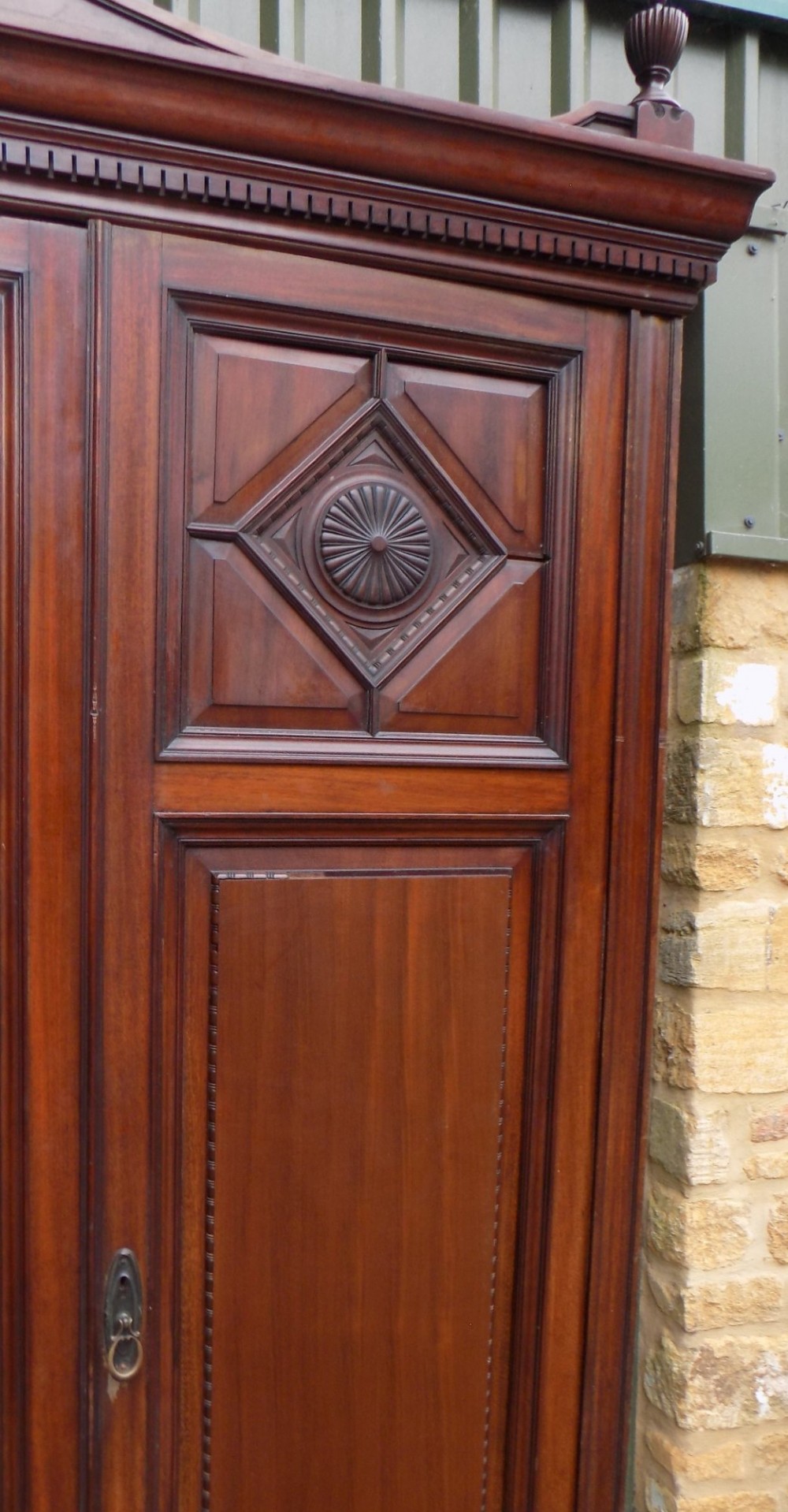 A late Victorian mahogany triple door wardrobe featuring a central full-length mirror, carved diamond relief panels, and a carved crest pediment. View VIII