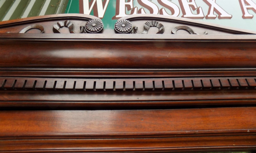 A late Victorian mahogany triple door wardrobe featuring a central full-length mirror, carved diamond relief panels, and a carved crest pediment. View IX