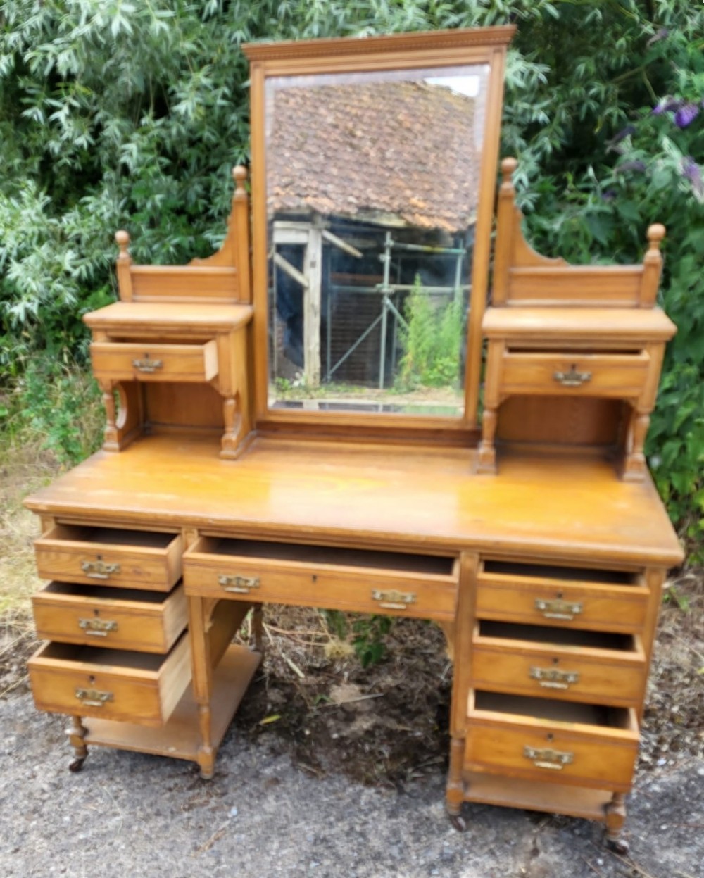 An Edwardian Arts and Crafts oak and ash bedroom suite comprising a mirror-door wardrobe with inlaid panels and a matching pedestal dressing table. View IV