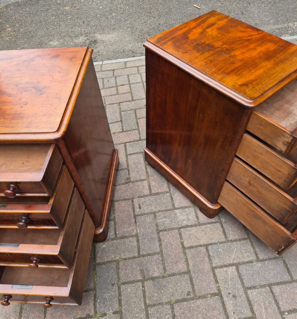 A matching pair of narrow Victorian mahogany bedside chests, each featuring four drawers with turned wooden knobs and a plinth base. View V