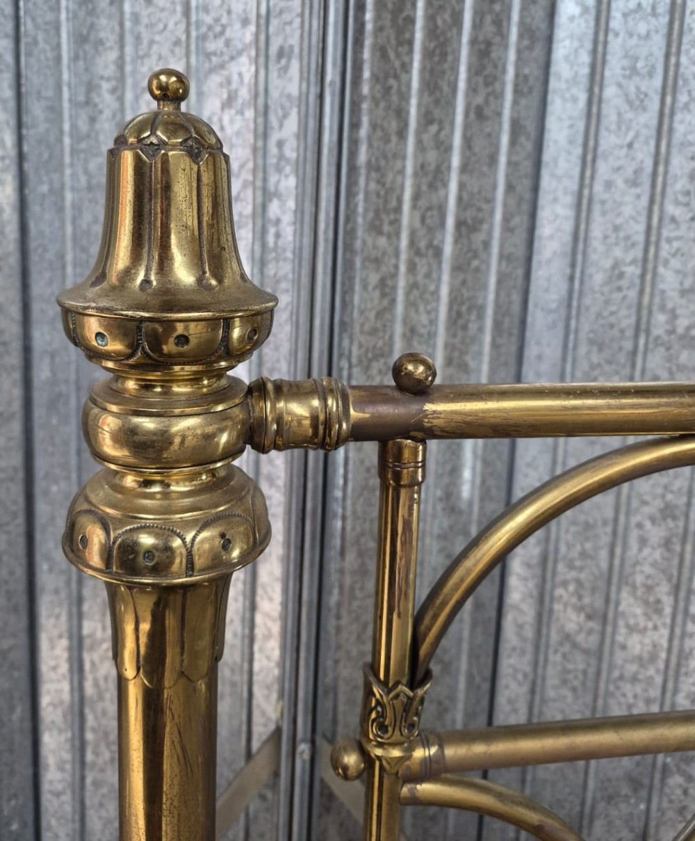 Victorian brass king-size bedstead featuring Gothic tracery arch designs on the headboard and footboard with decorative corner finials. View II