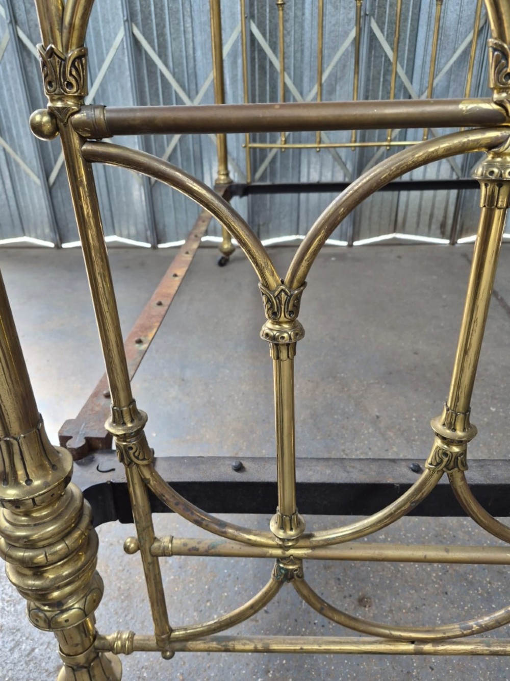 Victorian brass king-size bedstead featuring Gothic tracery arch designs on the headboard and footboard with decorative corner finials. View IV