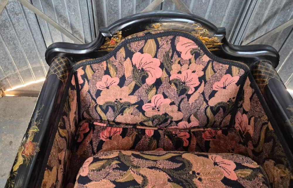 A three-piece Edwardian seating suite comprising a central two-seater settee and two matching armchairs with black lacquered frames adorned with gilded Chinoiserie patterns and pink floral pattern fabric upholstery. View II