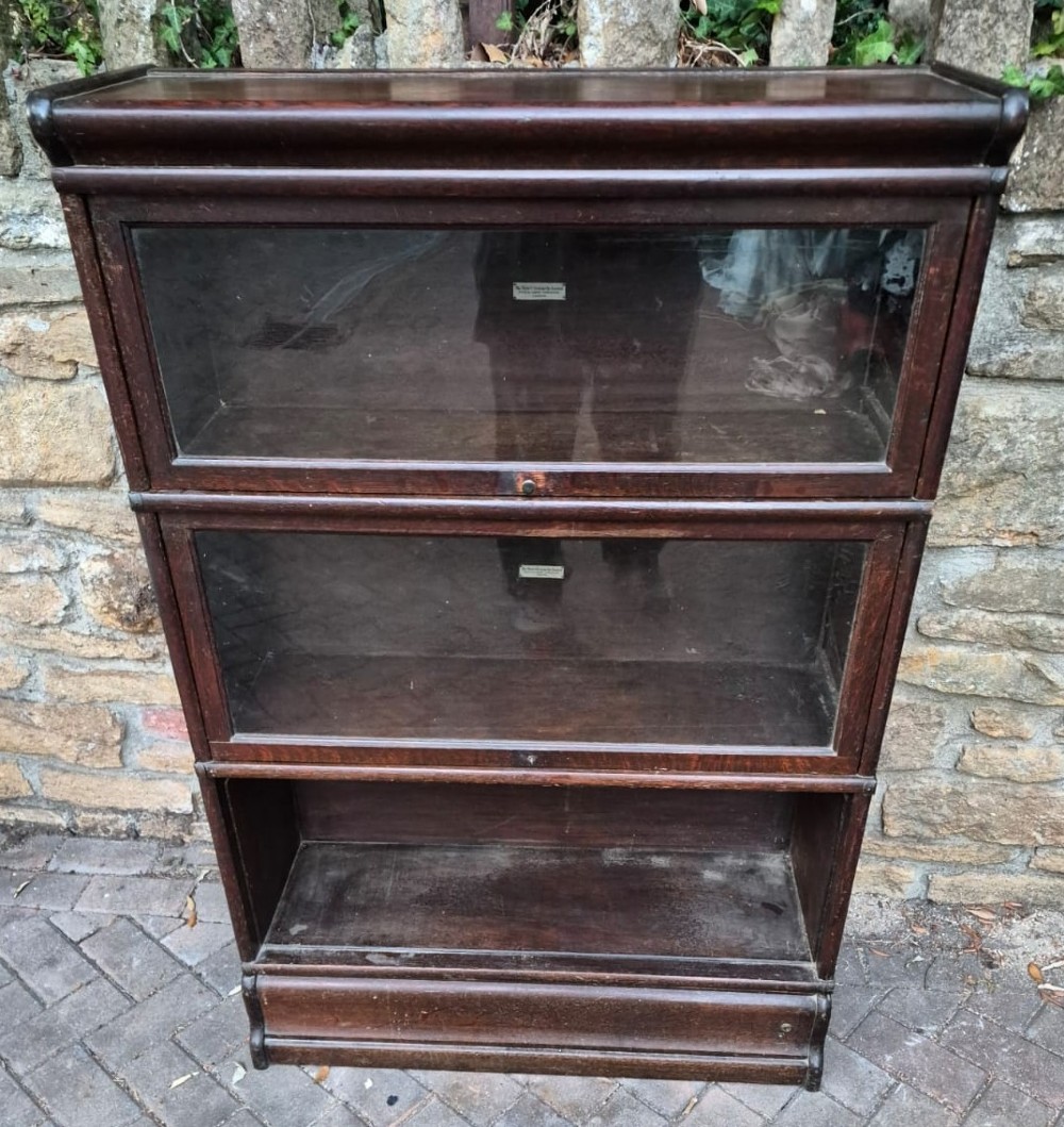 A dark oak three-tier Globe Wernicke sectional bookcase featuring glazed up-and-over doors.