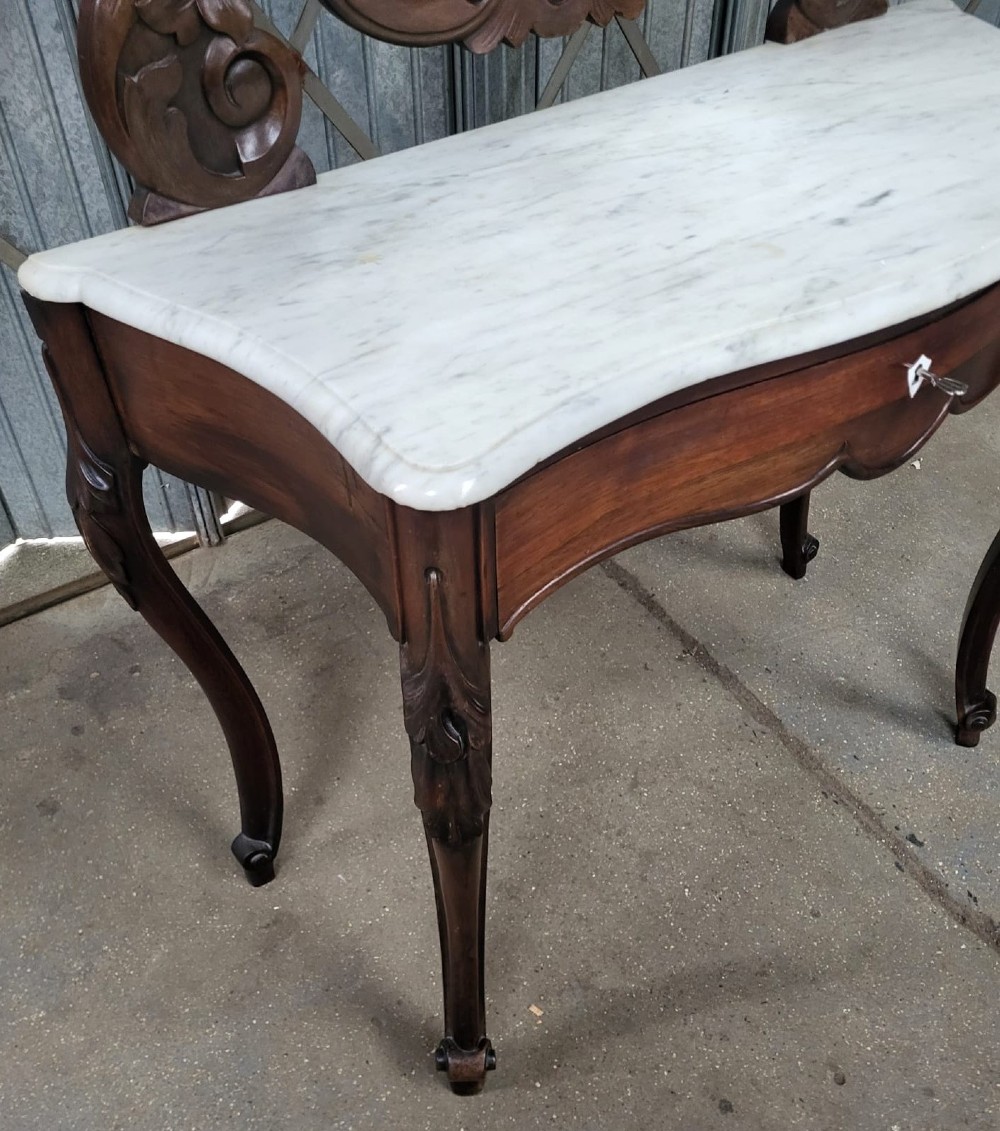 A French walnut dressing table featuring an attached carved mirror, a white marble surface, a single drawer, and cabriole legs. View III