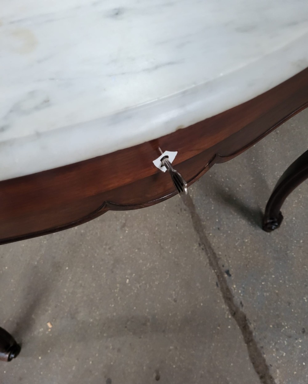 A French walnut dressing table featuring an attached carved mirror, a white marble surface, a single drawer, and cabriole legs. View IV