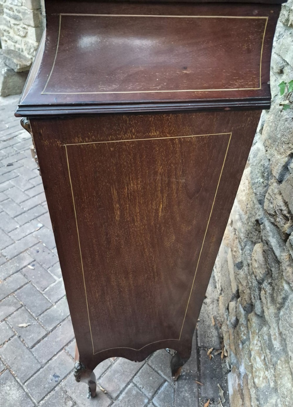 An Edwardian dark wood display cabinet featuring floral marquetry inlays, a single curved glass glazed door, cabriole legs, and a brass top gallery. View III